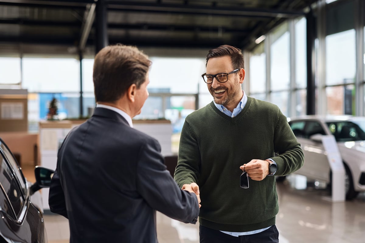 Happy customer shaking hands with a representative after receiving keys